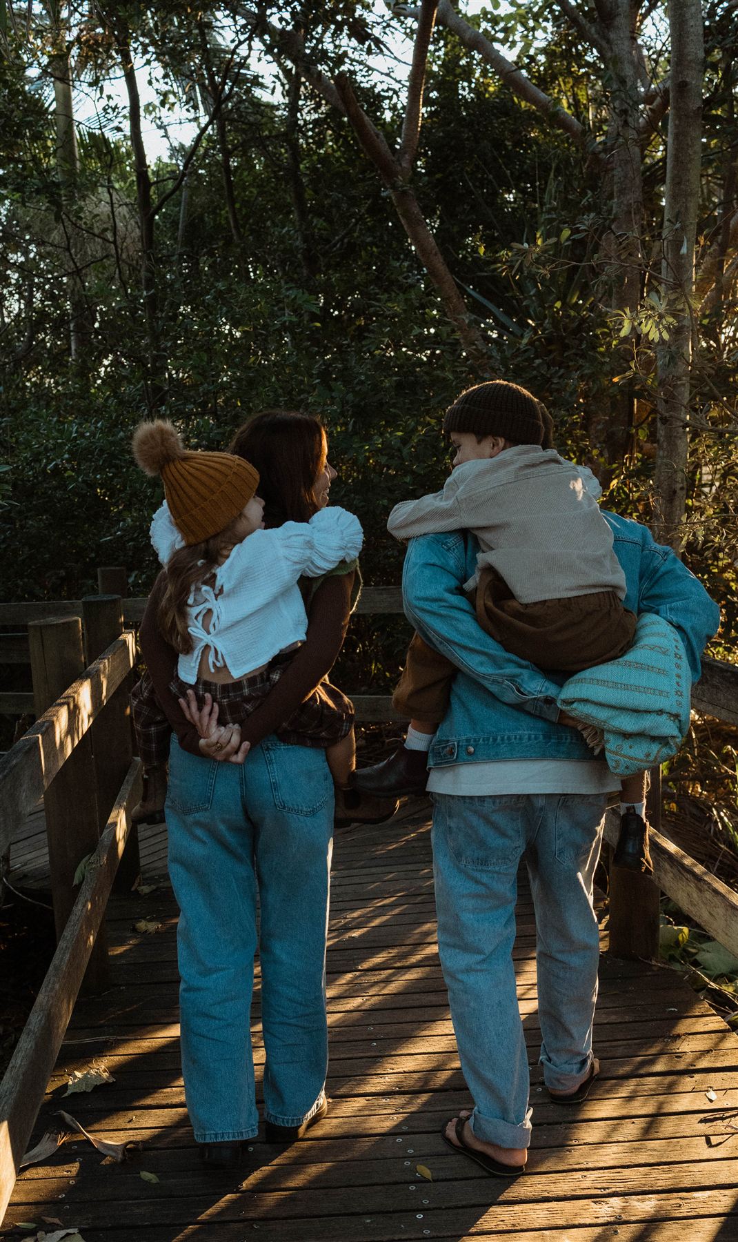 Roberta of Bertie Photography — headshot coming soon; a family walks a boardwalk in golden light